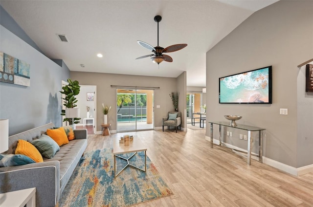 living room with ceiling fan, light hardwood / wood-style flooring, and lofted ceiling