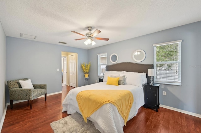 bedroom featuring a textured ceiling, ceiling fan, and dark wood-type flooring