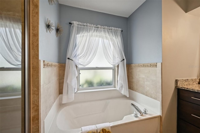 bathroom with a tub to relax in, vanity, and tile walls