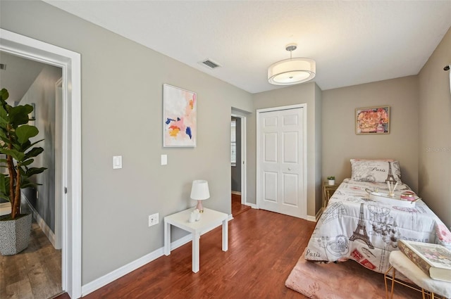 bedroom with a closet and dark wood-type flooring