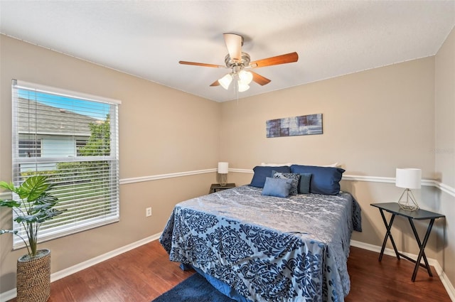 bedroom with multiple windows, ceiling fan, and dark hardwood / wood-style flooring