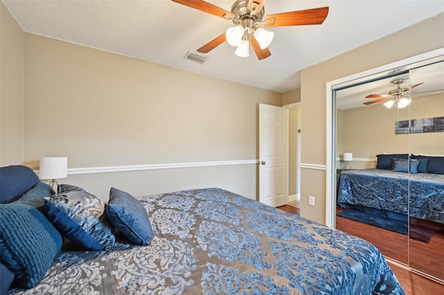 bedroom with hardwood / wood-style floors, a closet, and ceiling fan