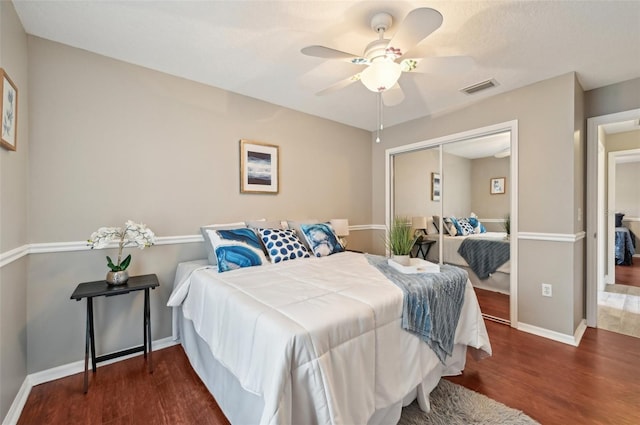 bedroom featuring ceiling fan, a closet, and dark wood-type flooring