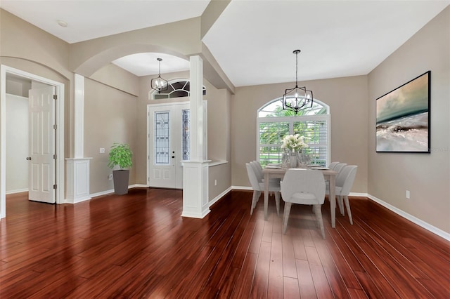 unfurnished dining area with dark wood-type flooring and an inviting chandelier