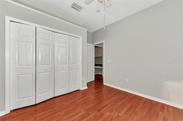 unfurnished bedroom featuring wood-type flooring, a closet, and ceiling fan