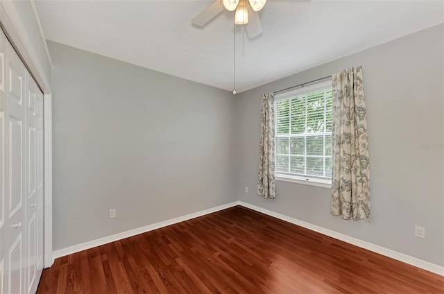 unfurnished bedroom with ceiling fan, a closet, and hardwood / wood-style flooring