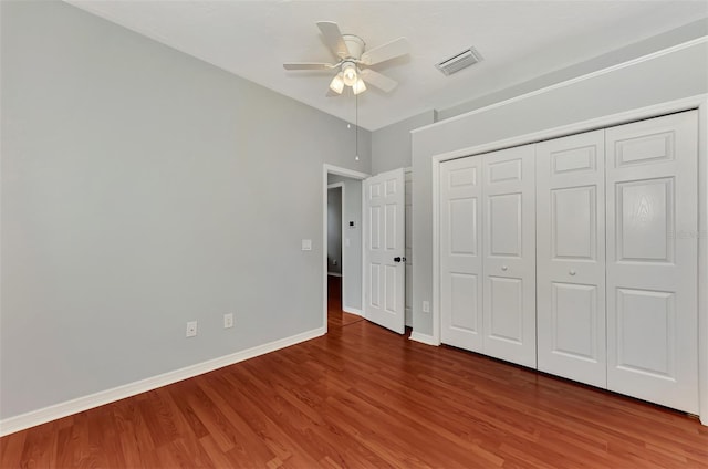 unfurnished bedroom featuring ceiling fan, a closet, and hardwood / wood-style flooring