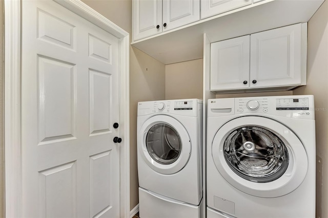 washroom with washer and clothes dryer and cabinets