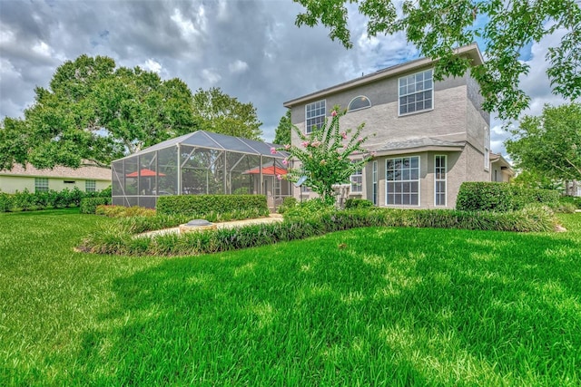 back of property with glass enclosure and a yard