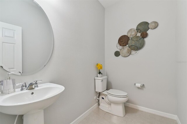 bathroom with tile flooring, sink, and toilet