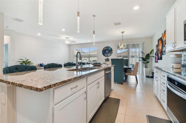 kitchen featuring ceiling fan, a center island with sink, sink, white cabinetry, and appliances with stainless steel finishes