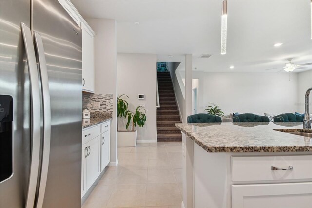 kitchen with stainless steel fridge with ice dispenser, light tile flooring, backsplash, ceiling fan, and white cabinetry