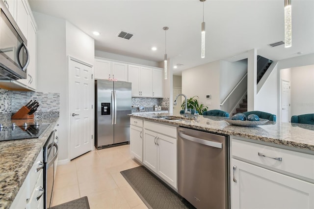 kitchen featuring stainless steel appliances, backsplash, light tile floors, sink, and white cabinets