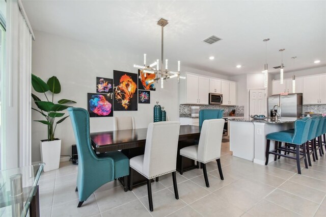 dining space with an inviting chandelier and light tile floors