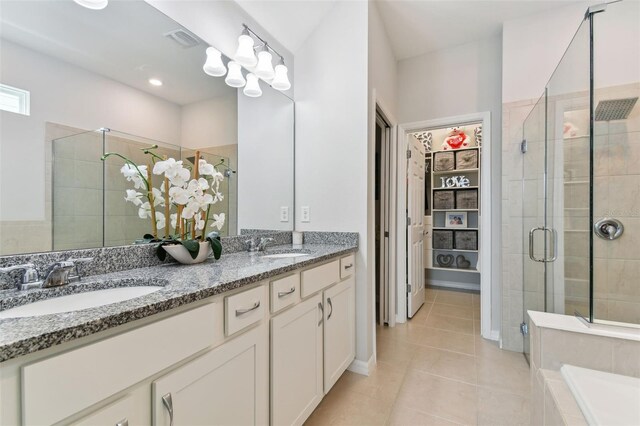 bathroom featuring tile floors, independent shower and bath, dual sinks, and vanity with extensive cabinet space