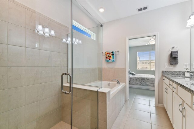 bathroom with tile flooring, plus walk in shower, vanity, and ceiling fan