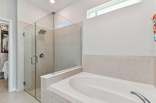 bathroom with shower with separate bathtub and tile flooring