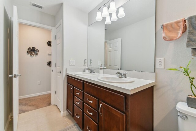 bathroom featuring tile flooring, double sink vanity, and toilet