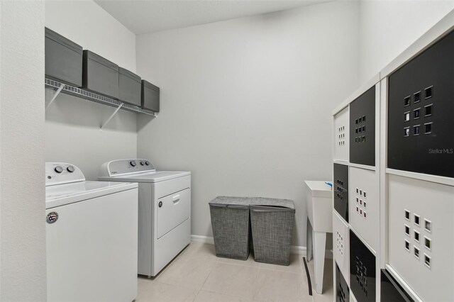 laundry room with separate washer and dryer and light tile floors