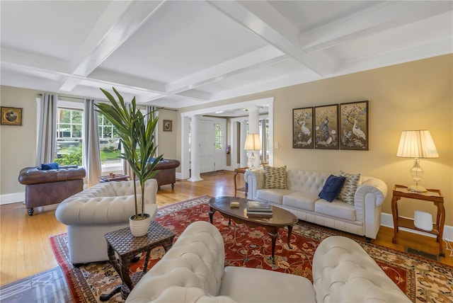 living room with ornate columns, coffered ceiling, light hardwood / wood-style flooring, and beamed ceiling