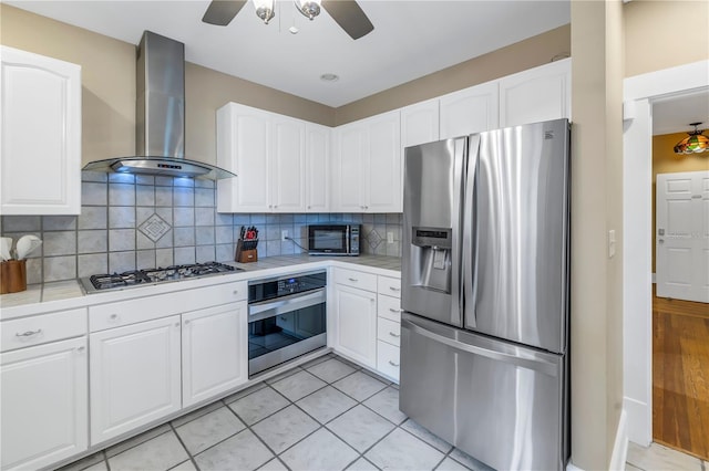 kitchen with white cabinetry, backsplash, wall chimney exhaust hood, and appliances with stainless steel finishes