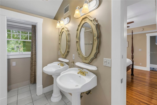 bathroom featuring lofted ceiling, dual sinks, and tile patterned floors