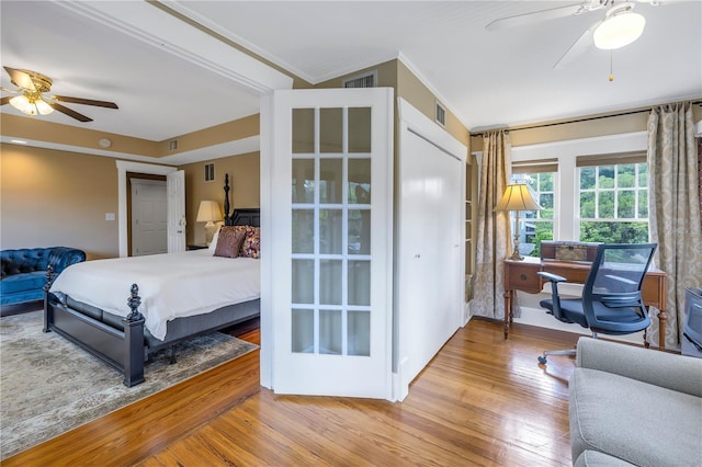 bedroom featuring wood-type flooring, ornamental molding, and ceiling fan