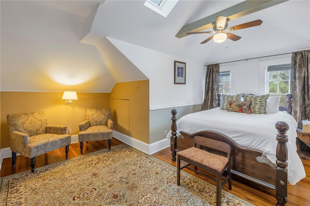 bedroom with ceiling fan, wood-type flooring, and lofted ceiling with skylight