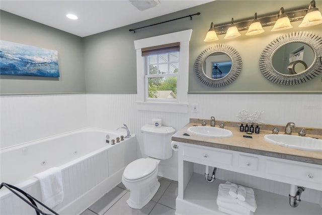 bathroom with a bathing tub, vanity, tile patterned floors, and toilet