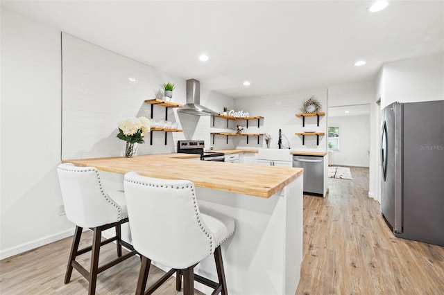 508 Brooker Rd, Brandon, FL 33511 - kitchen featuring open shelves, stainless steel appliances, a peninsula, wall chimney exhaust hood, and wooden counters