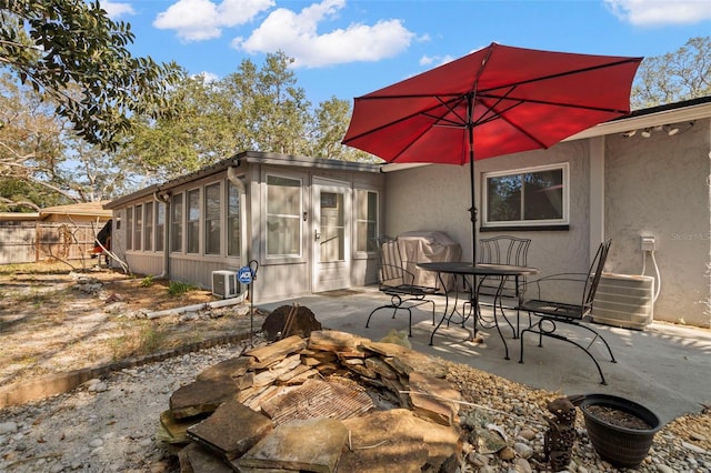 view of patio with a sunroom and central air condition unit