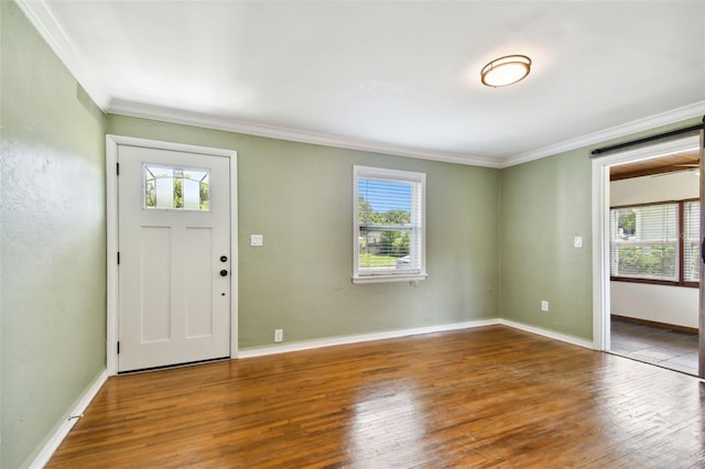 foyer entrance with hardwood / wood-style floors, crown molding, and a healthy amount of sunlight