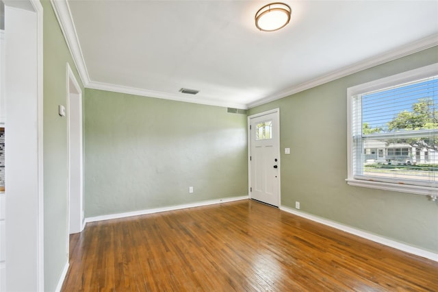 entrance foyer featuring hardwood / wood-style flooring, a wealth of natural light, and ornamental molding