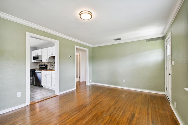 spare room featuring hardwood / wood-style floors and crown molding