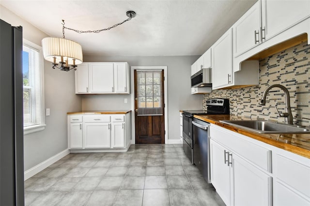 kitchen with wood counters, sink, white cabinetry, and stainless steel appliances