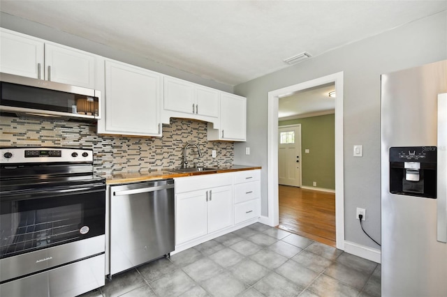 kitchen with white cabinetry, sink, wood counters, tasteful backsplash, and appliances with stainless steel finishes