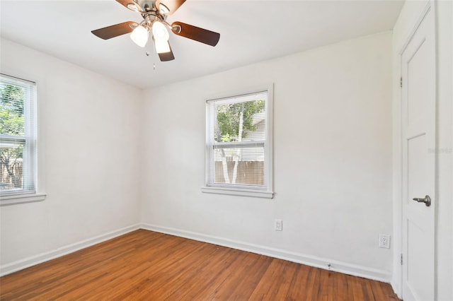 empty room featuring a healthy amount of sunlight, ceiling fan, and wood-type flooring