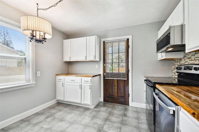 kitchen featuring white cabinets, appliances with stainless steel finishes, wood counters, and pendant lighting