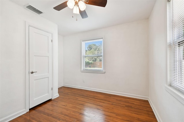 empty room with dark hardwood / wood-style flooring and ceiling fan