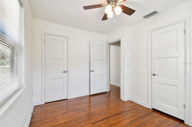 unfurnished bedroom featuring ceiling fan and dark hardwood / wood-style floors