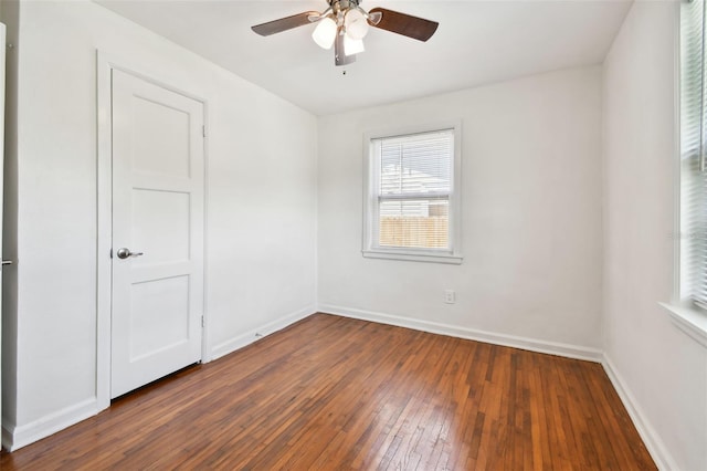 unfurnished room with ceiling fan and dark wood-type flooring