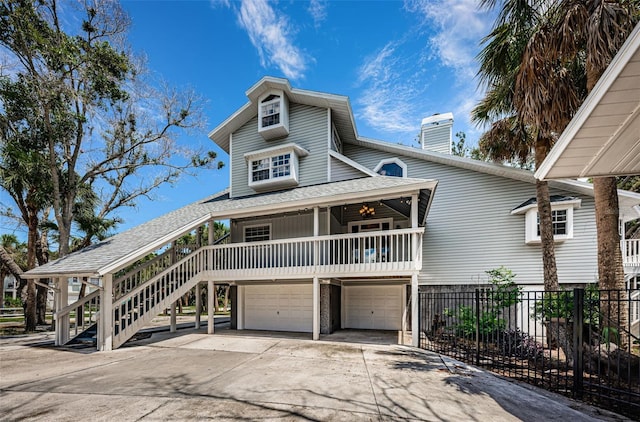 coastal inspired home featuring covered porch and a garage