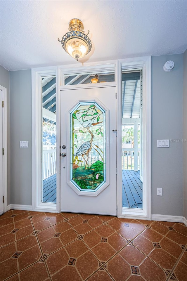 entrance foyer with dark tile patterned flooring and a textured ceiling