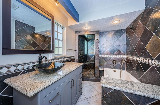 bathroom featuring tile patterned floors, a textured ceiling, shower with separate bathtub, vanity, and tile walls