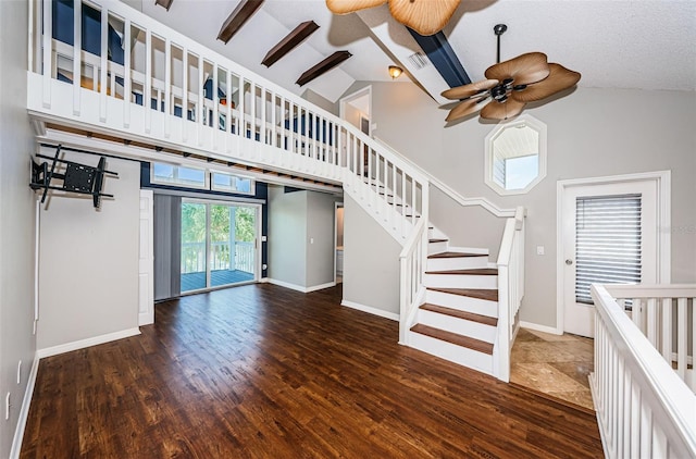 unfurnished living room featuring beamed ceiling, ceiling fan, dark hardwood / wood-style flooring, and high vaulted ceiling