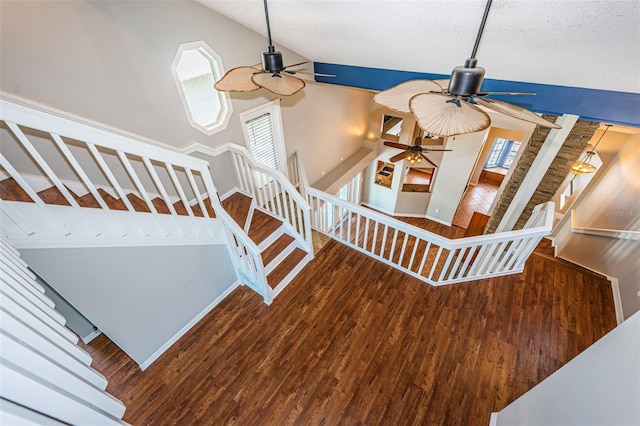 stairway featuring hardwood / wood-style flooring, high vaulted ceiling, and ceiling fan