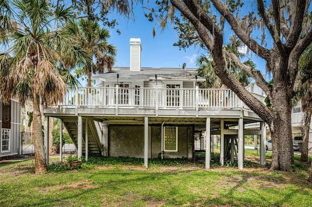 rear view of house with a yard and a deck