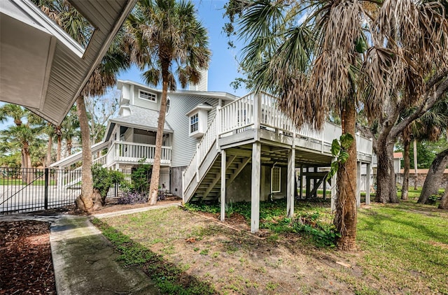 rear view of house featuring a lawn and a wooden deck