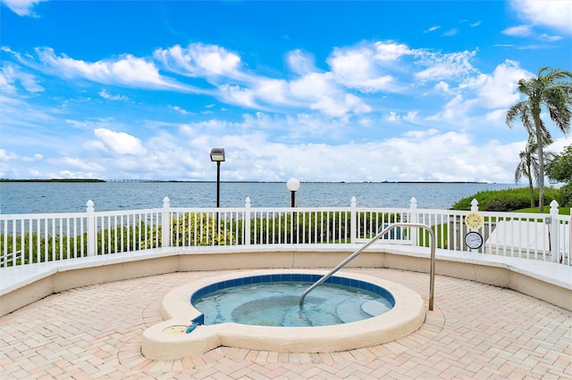 view of pool featuring an in ground hot tub and a water view