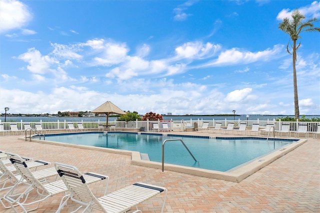 view of swimming pool with a patio area and a water view